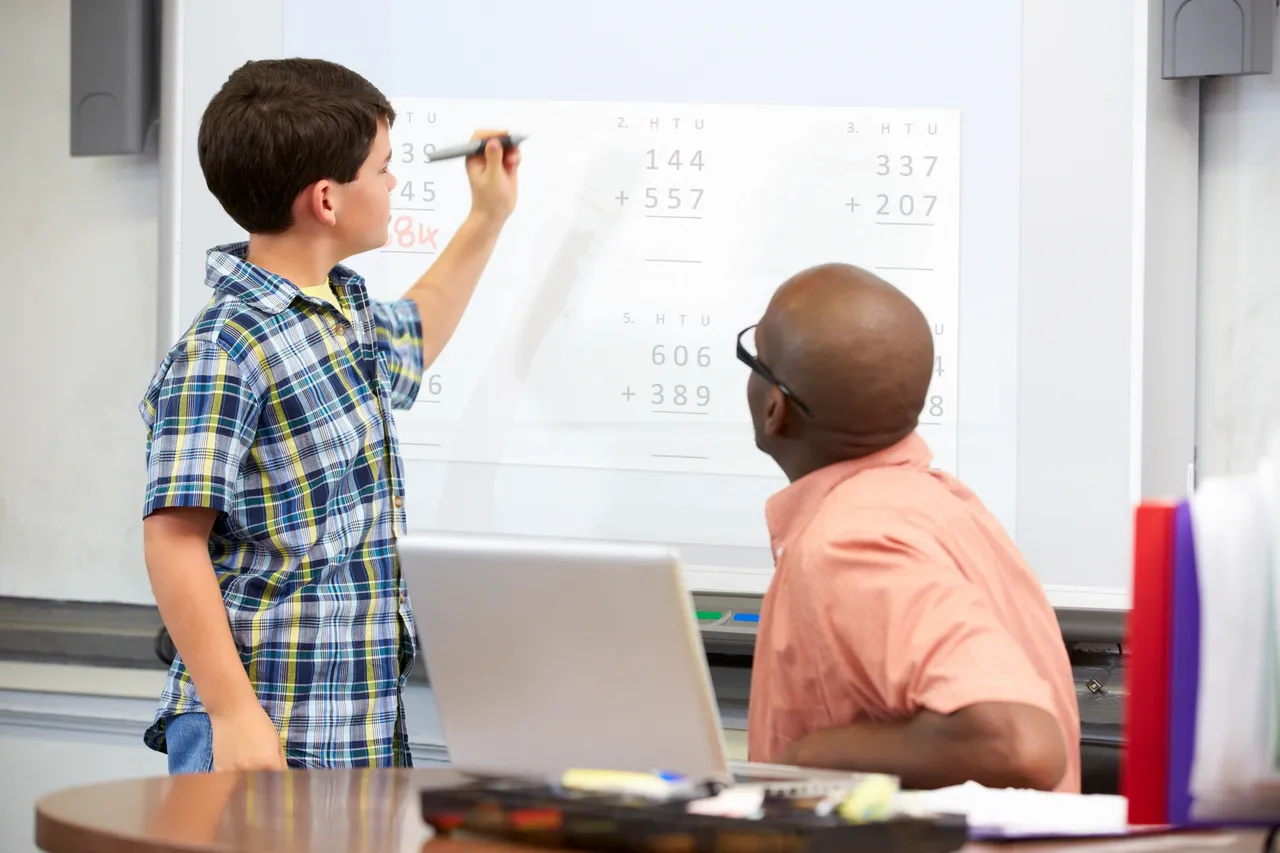Student solving math problem on board
